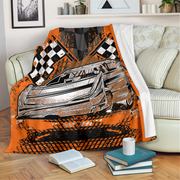 Car-themed blanket with checkered pattern draped over a chair in a living room.