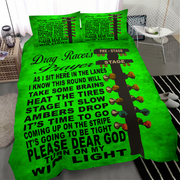 A bright green bedding set with a black and white drag racer prayer text design and multicolored bow tie graphics, shown on a bed in a modern bedroom setting.