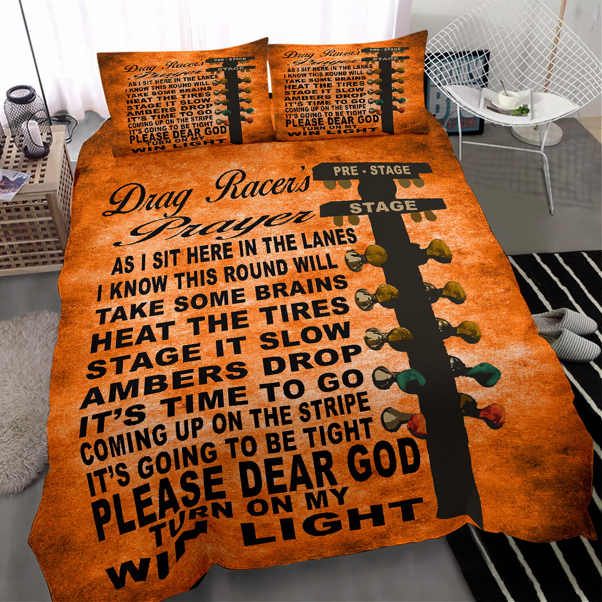 A bed dressed in an orange and black drag racer themed bedding set, featuring a large drag racer prayer text design and a guitar headstock graphic with colorful taillights. The set includes a duvet cover and two matching pillowcases, shown in a modern bedroom setting.