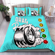 A turquoise drag racing themed bedding set featuring a duvet cover and two matching pillowcases with a graphic of a spinning tire, smoke, and the words 'DRAG Racing' alongside traffic light graphics, shown on a bed in a styled bedroom.