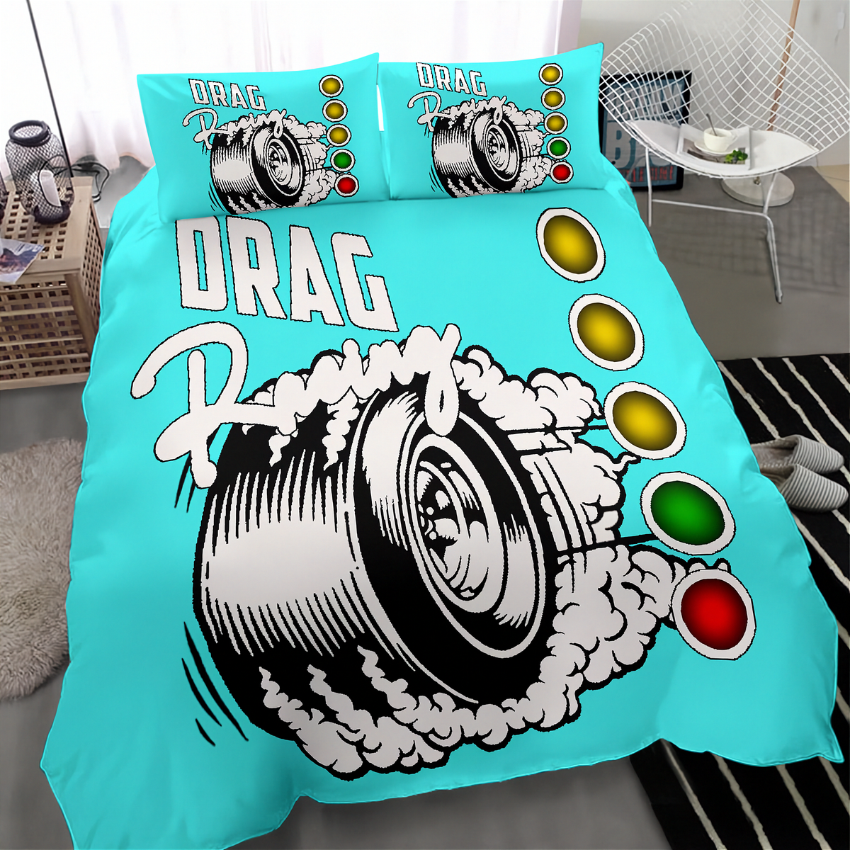 A bright turquoise bedding set featuring a large drag racing tire graphic with smoke and the words 'DRAG Racing,' plus matching pillowcases. The set is shown on a bed in a styled bedroom with a chair, side table, rug, and slippers visible.