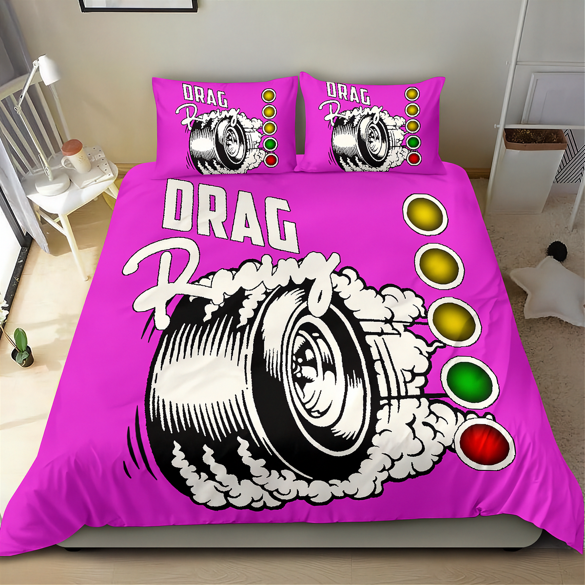 A bright pink drag racing themed bedding set, including a duvet cover and two matching pillowcases, displayed on a bed in a bedroom setting. The design features a large black and white tire graphic with white smoke, the words 'DRAG Racing', and a vertical sequence of green, yellow, and red light circles.