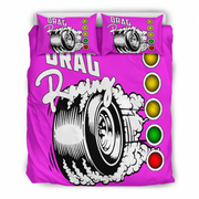 A bright pink bedding set featuring a duvet cover and two matching pillowcases with a drag racing graphic design. The design includes a black and white tire with smoke, the words 'DRAG Racing', and a vertical sequence of yellow, gold, green, and red oval lights.