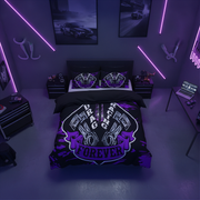 A styled bedroom scene with a bed dressed in a black and purple graphic bedding set. The duvet and pillowcases feature a large winged emblem with the words 'FIRE AND AGING FOREVER' in white and purple.