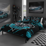 A racing-themed bedding set displayed on a bed in a modern gray bedroom. The set includes a duvet cover and two matching pillowcases featuring a black background with bright teal paint splatters and a large 'Racing Painters' graphic.