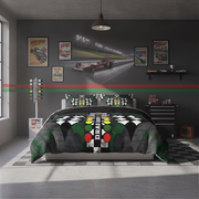 A racing-themed bedding set displayed on a bed in a modern, dark gray racing simulator themed bedroom. The comforter and matching pillowcases feature a black and white checkered pattern, a green and black track background, and illuminated green, yellow, and red race lights with the word 'DRAG' in the center.