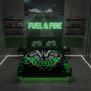 A modern bedroom setup featuring a black and green racing-themed bedding set with a large 'Engine Racer Forever' graphic on the duvet and matching pillowcases. The room is styled with a concrete wall, shelves displaying miniature cars, and a neon sign on the wall that reads 'FUEL & FIRE'.