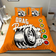 Bright orange bedding set with a drag racing tire graphic, white smoke effects, and red/yellow/green traffic light accents, shown on a bed in a bedroom with matching pillowcases.