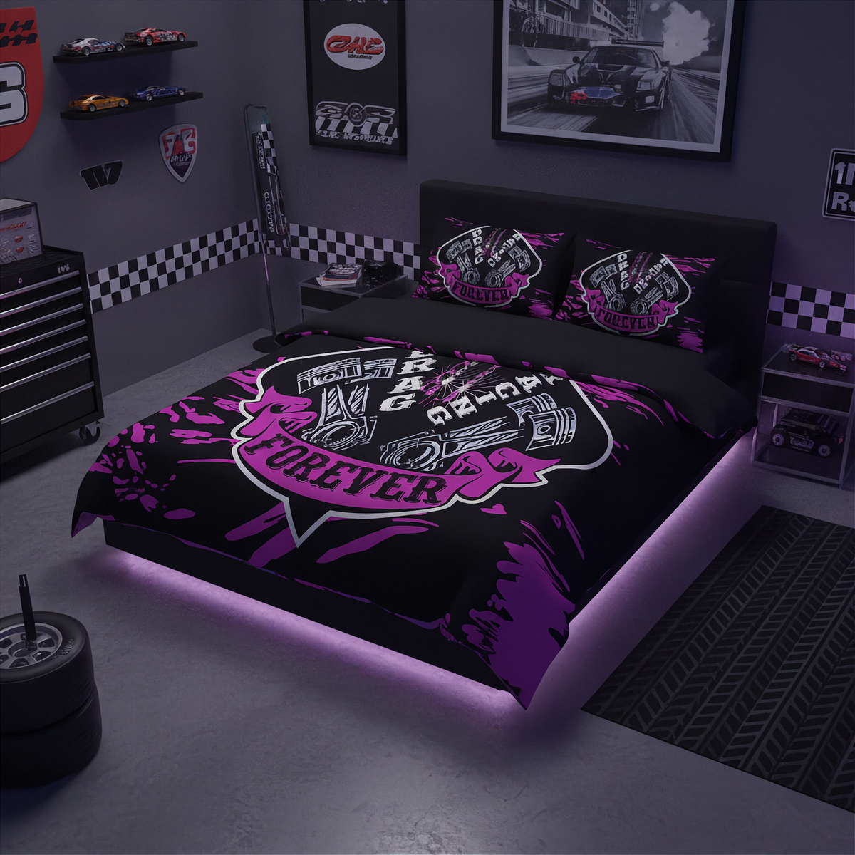 A racing-themed bedding set featuring a duvet cover and two pillowcases with a black background, purple paint splatters, and a large central shield graphic with a piston illustration and the words 'Racing Forever'. The bed is styled in a dark gray garage-themed bedroom with racing decals, toy cars, and a tire prop.