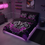 A black bedding set with a bold purple and white go-kart racing graphic, displayed on a bed in a themed bedroom with racing decals, toy cars, and a neon sign.