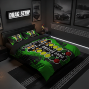 A dark-themed bedroom set featuring a duvet cover and two matching pillowcases with a vibrant green and black drag racing graphic. The room is styled with automotive posters, a 'DRAG STRIP' sign, and track-inspired decor.