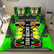 A bed dressed with a racing-themed bedding set featuring a black and neon green drag racing track design with yellow, green, and red signal lights, plus matching pillowcases, shown in a bedroom setting.