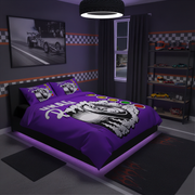 A purple racing-themed bedding set with a large wing graphic and 'WORLD CHAMPION' text, styled on a bed in a dark gray racing-themed bedroom with a tire lamp, car wall art, and toy shelves.