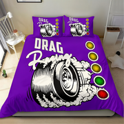A purple drag racing themed bedding set including a duvet cover and two matching pillowcases, displayed on a bed in a bedroom setting. The design features a large black and white tire graphic with white smoke, the words 'DRAG Racing', and a vertical sequence of yellow, gold, green, and red traffic light circles.