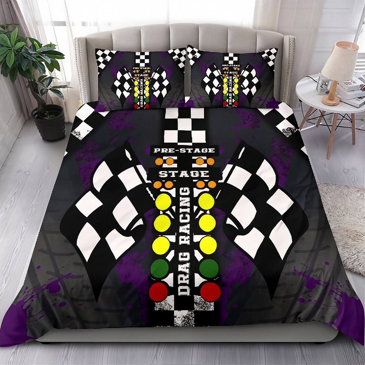 A bedding set featuring a duvet cover and two pillowcases with a drag racing theme, displayed on a bed in a modern bedroom setting. The design includes black and white checkered flags, a central starting-button motif in yellow, green, and red, and purple paint splatters on a dark gray background.