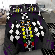 A bedding set featuring a duvet cover and two pillowcases with a drag racing theme, displayed on a bed in a modern bedroom setting. The design includes a black and white checkered flag motif, the words 'PRE-STAGE', 'STAGE', and 'DRAG RACING', and a vertical sequence of yellow, green, and red lights on a black background with purple paint splatters.