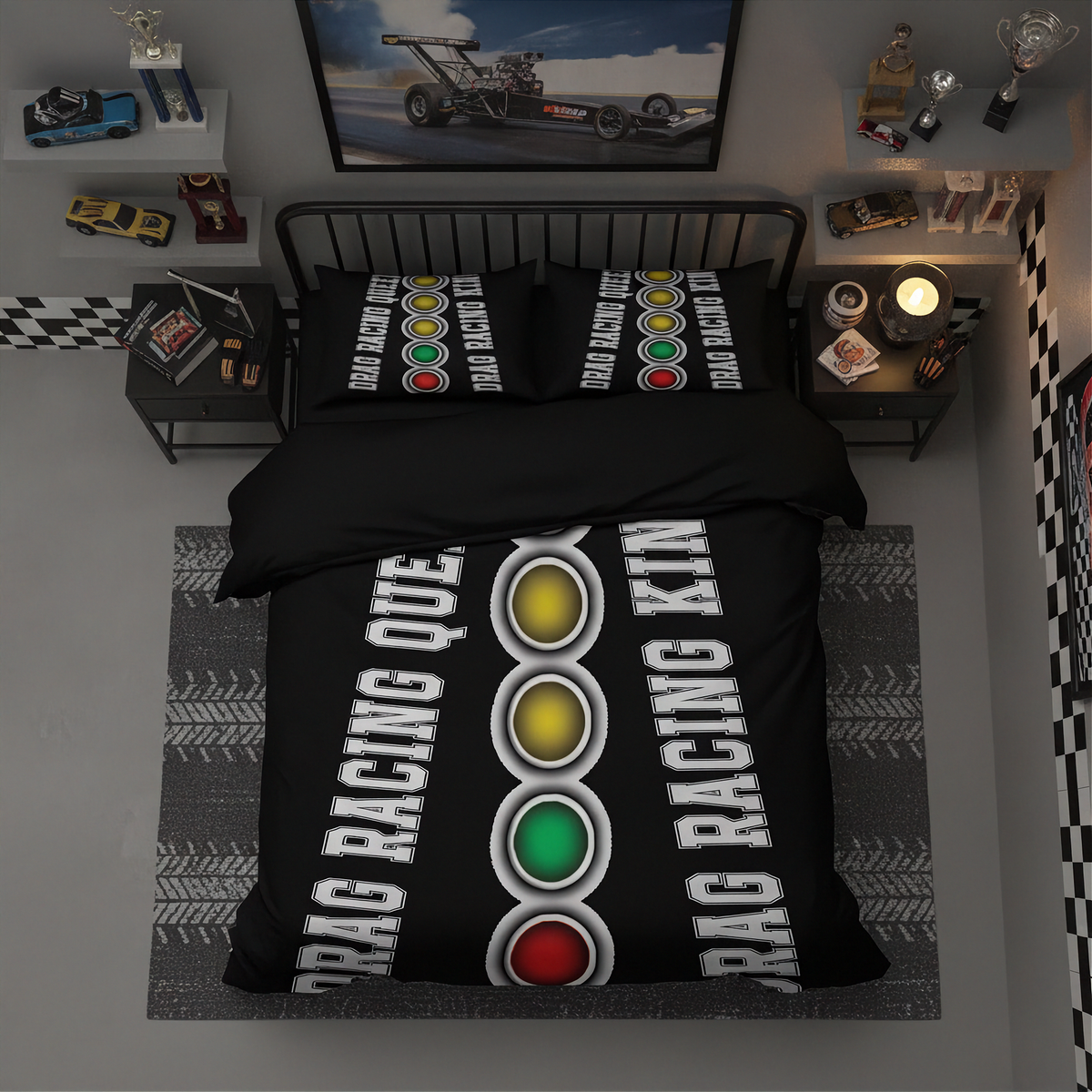 A top-down view of a bed dressed in a black drag racing themed bedding set, featuring a duvet cover and two matching pillowcases with a vertical traffic light graphic and white 'DRAAG RACING KING' text. The bed is styled in a dark gray bedroom with racing memorabilia, including a framed drag race poster, toy cars, and a checkered accent on the wall.