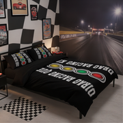 A racing-themed bedding set displayed on a bed in a styled bedroom. The set includes a black duvet cover and matching pillowcases printed with white 'DRAG RACING QUEEN' text and three signal lights in yellow, green, and red.