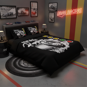A black drag racing themed bedding set with a large white graphic and colored wheel decals, styled in a modern gray garage-themed bedroom with racing posters and a neon sign.