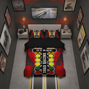 A styled bedroom scene showing a bed dressed in a drag racing themed bedding set. The set includes a duvet cover and two pillowcases with a bold red, black, yellow, and white graphic featuring the words 'DRAG RACING' and 'STAGE'.