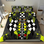 A bedding set featuring a racing-themed print with checkered flags, neon yellow paint splatters, and a drag racing control panel graphic on a black background, shown on a bed in a bedroom setting.