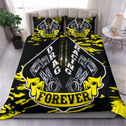 A bed dressed in a black racing-themed bedding set with two matching pillowcases. The duvet and pillows feature a large central shield graphic with pistons, the words 'DRAG RACING', and a yellow banner reading 'FOREVER', surrounded by bright yellow paint-splatter accents.