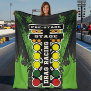 Woman on a drag track holding a green drag racing blanket