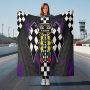 woman holding a drag racing themed blanket on a race track