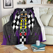 Decorative blanket with drag racing design on a couch in a living room.