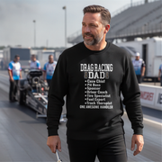 Man wearing a black sweatshirt with 'Drag Racing Dad' text at a race track.