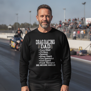 Man wearing a black sweatshirt with 'Drag Racing Dad' text at a race track.