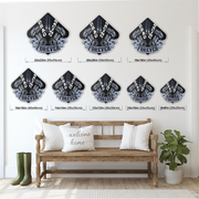 Eight black and white diamond-shaped wall metal signs with crossed tools and the word 'DRAG RACING FOREVER' are displayed on a white wall above a wooden bench with pillows, with size labels beneath each decal.