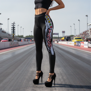 Woman wearing black leggings with drag racing Christmas tree design on a race track