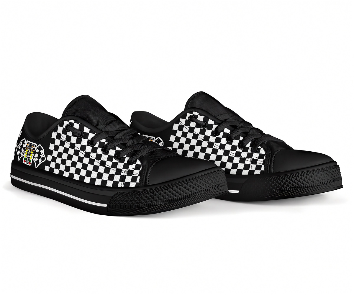 A pair of low-top sneakers with a black and white checkerboard pattern on the sides, black toe caps, black laces, and black soles. One shoe features a small graphic patch on the heel.