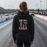 Person wearing a black hoodie with 'Drag Racing USA' text at a race track.