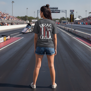 Person wearing a 'Drag Racing USA' t-shirt on a racetrack with spectators in the background