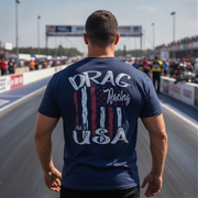 Man wearing a 'Drag Racing USA' t-shirt at a racing event.