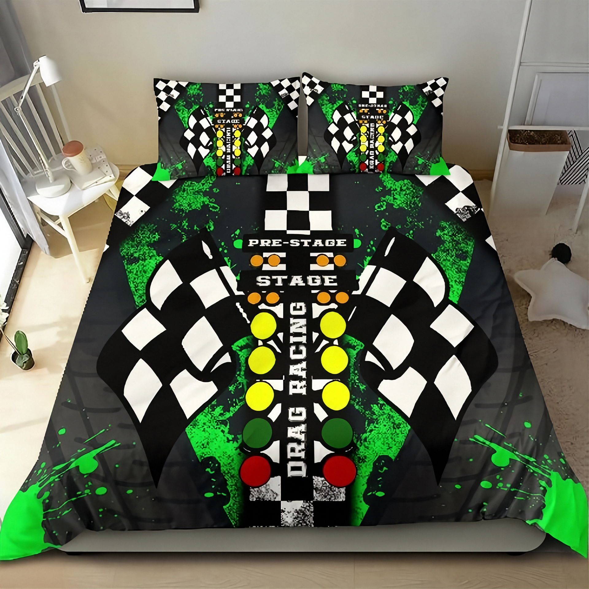 A drag racing-themed bedding set featuring a duvet cover and two matching pillowcases with a black and white checkered flag motif, green paint splatters, and a central vertical graphic with yellow, green, red, and white elements reading 'PRE-STAGE', 'STAGE', and 'DRAG RACING'. The set is displayed on a bed in a bedroom setting.