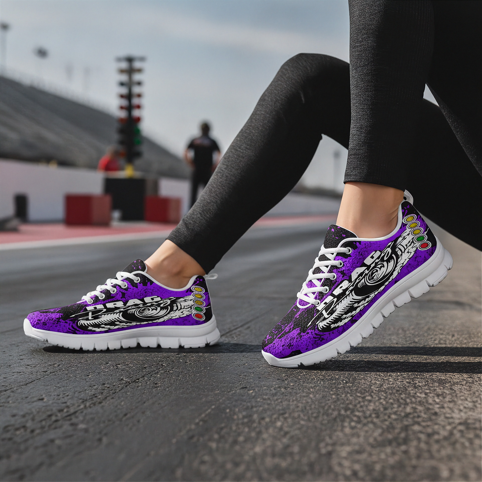 Purple and black sneakers with colorful accents worn on a track.