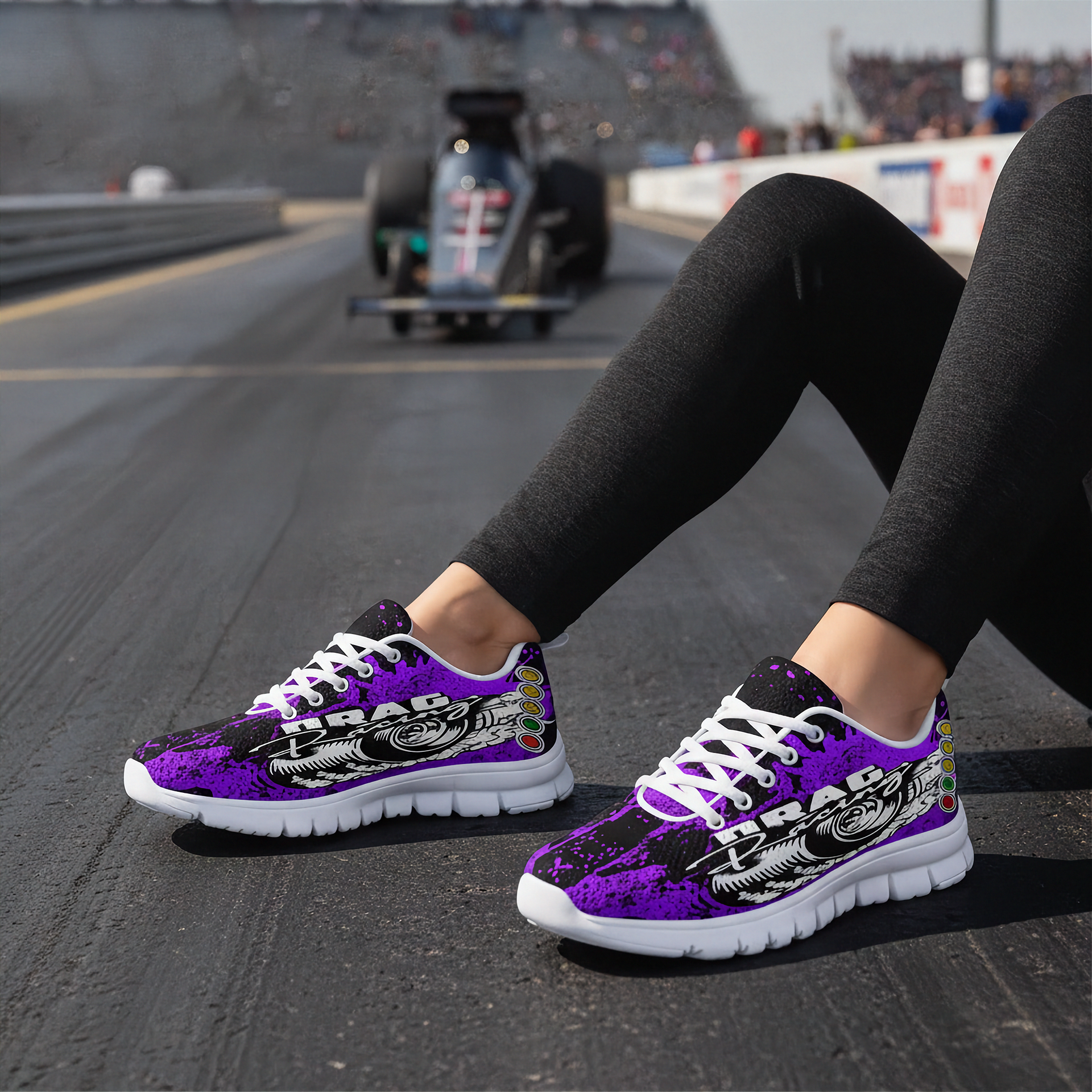 Purple and black sneakers with white soles on a racetrack.