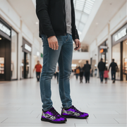 Person wearing blue jeans and purple sneakers in a shopping mall.