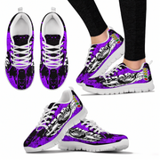 Purple and black sneakers with white soles worn by a person on a white background