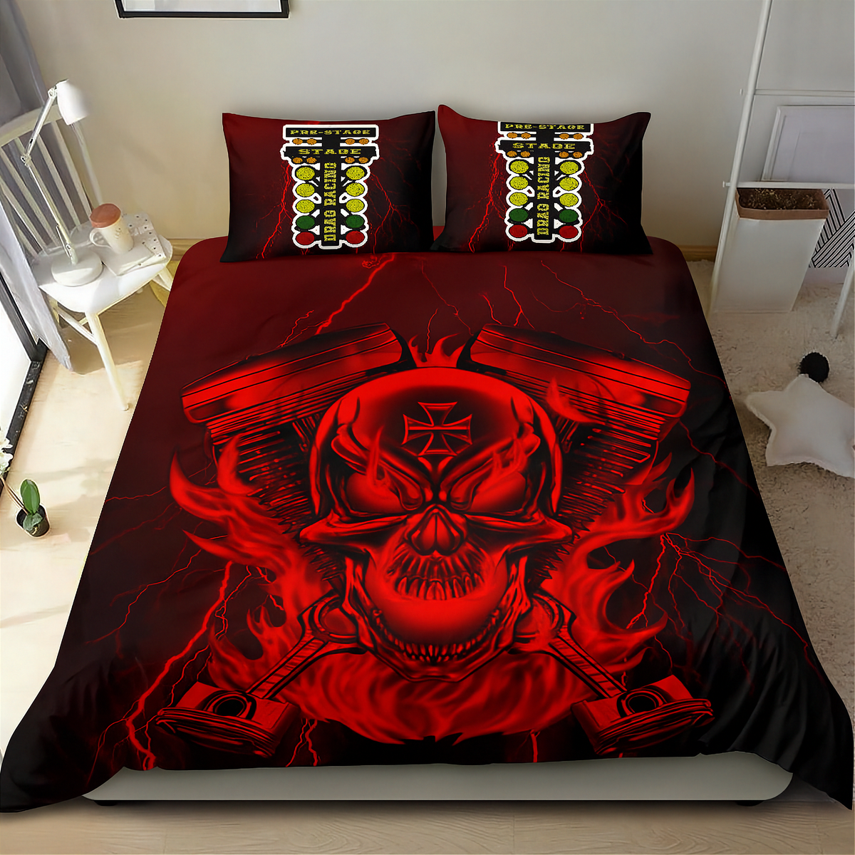 A bed dressed in a black bedding set featuring a large red skull graphic over crossed engine pistons, with matching pillowcases showing a vertical striped design. The bed is photographed in a styled bedroom setting with a white side table, lamp, and wall art visible.