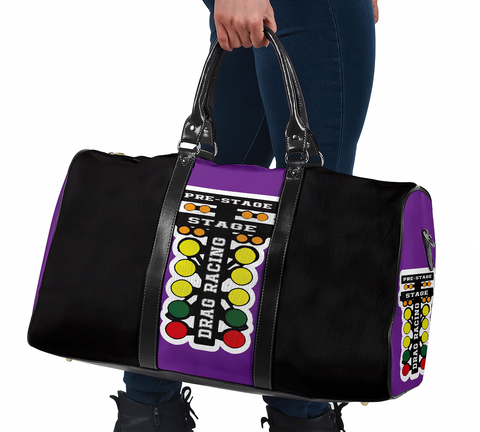 A black duffel bag with purple side panels and a colorful drag racing light graphic, held by a person wearing blue jeans against a white background.