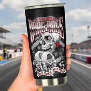 A hand holds a stainless steel travel tumbler with a black background and a detailed graphic of a skull, gears, and the text 'If You Wanna To Drag Race You'll Need A Set of These' against a blurred racetrack background.