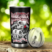 A black insulated tumbler with a stainless steel rim and base, featuring a detailed skull graphic with a red rose and the text 'If You Wanna To Drag Race You'll Need A Set of These', shown next to its clear lid on a wooden surface with a blurred green background.