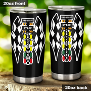 Two 20oz stainless steel tumbler cups shown side by side on a wooden surface with a blurred green outdoor background. The left cup shows the front design and the right cup shows the back design.