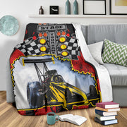 Dragster photo and name blanket on a gray sofa beside patterned cushions, with its white backing visible.