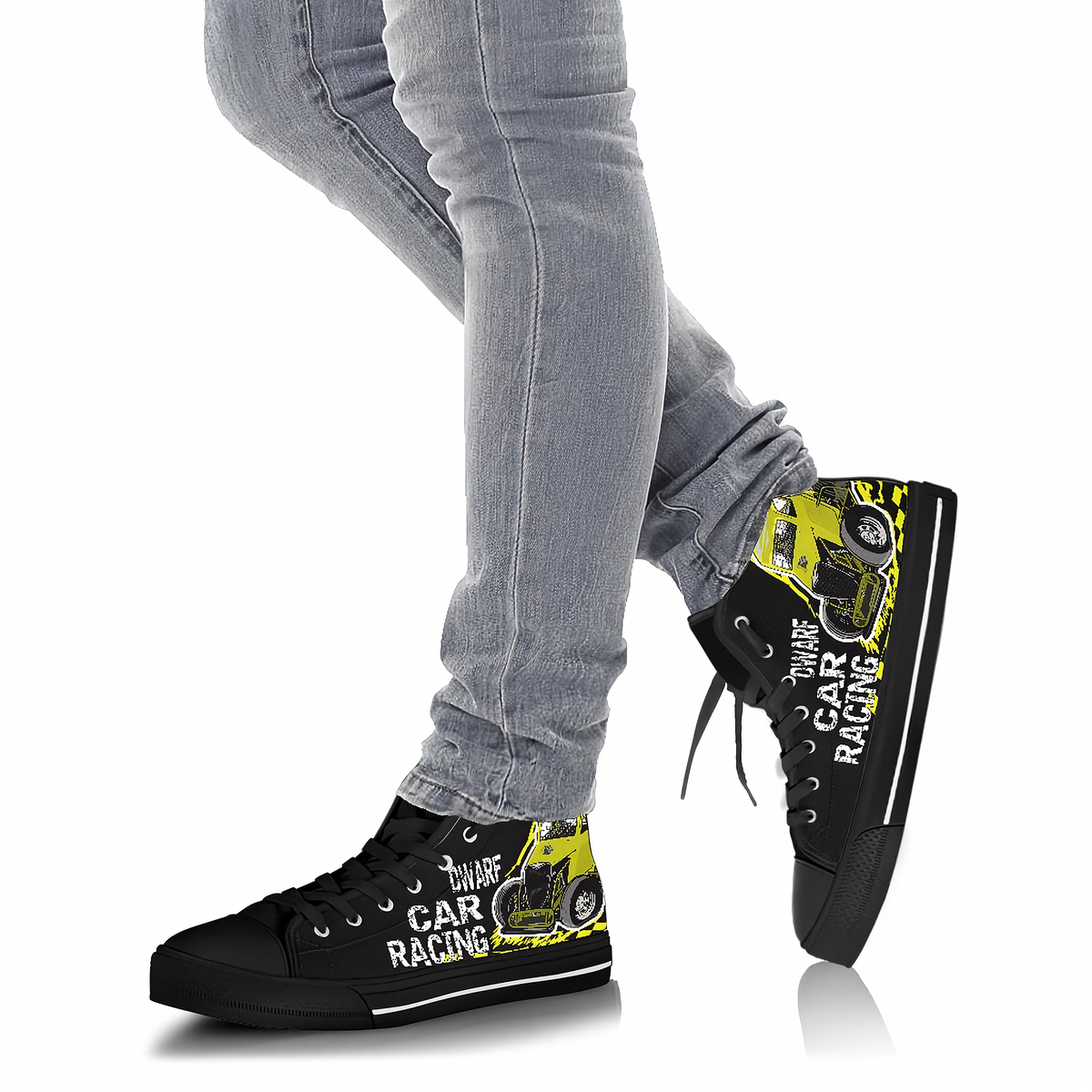 A person wearing black high-top sneakers with a yellow and black car racing graphic and white text, paired with light-wash gray jeans, shown against a plain white background.