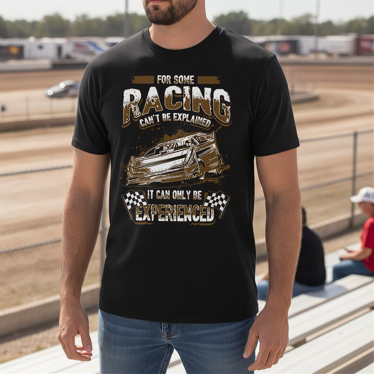 Man wearing a black t-shirt with dirt racing-themed design at a race track.